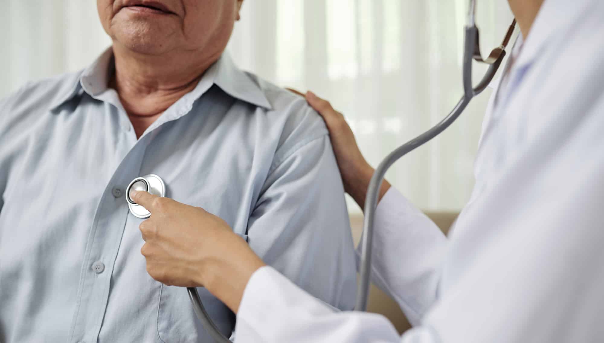 general practitioner checks a patient's heart beat