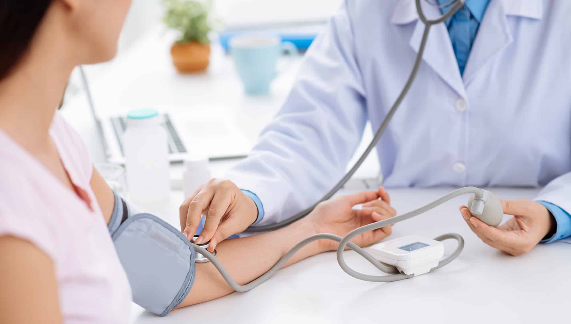 general practitioner checks a patient's blood pressure
