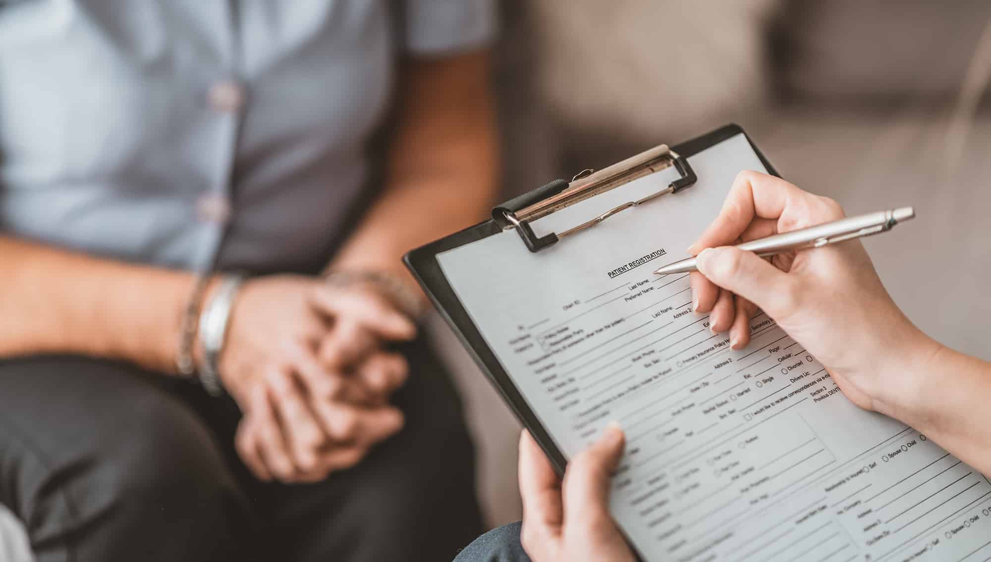 general practitioner filling out information for a patient